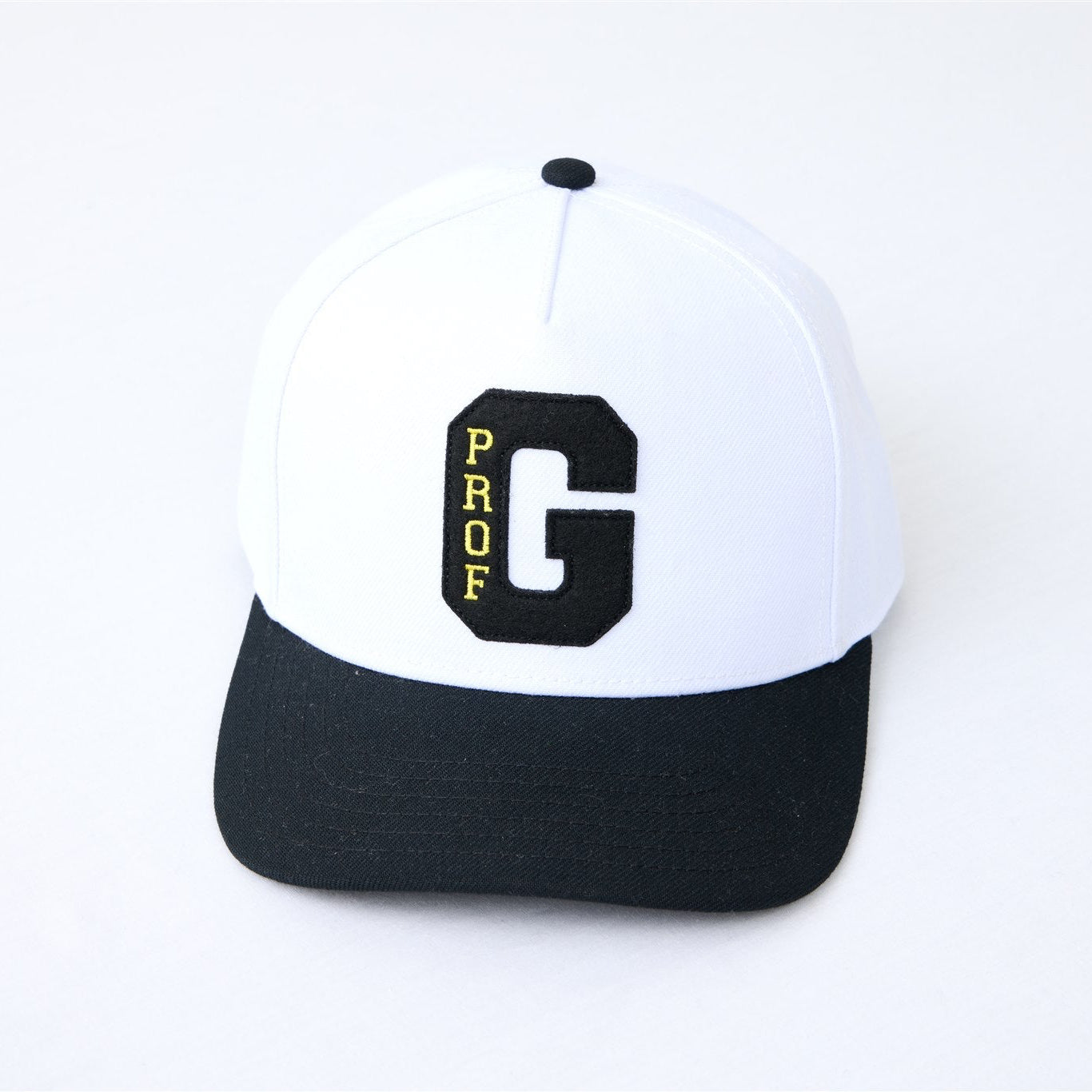 Black and white Collegiate snapback hat featuring embroidered Prof G varsity logo and structured curved brim.